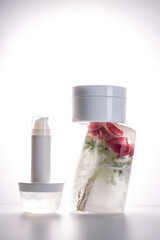Gel and a jar of serum on a background of ice with flowers.