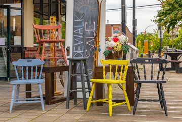 Vintage colorful wooden chairs on street flea market. Group of retro home wooden furniture on flea market street