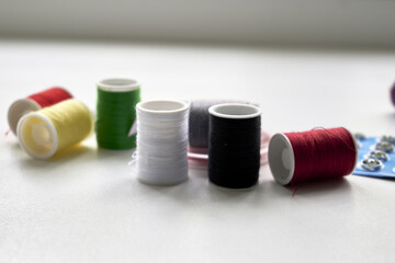 sewing kit thread needles pins and measuring tape on the table