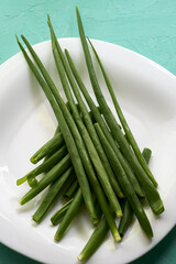 green onion leaves on a white plate on the table