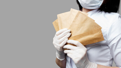 Professional manicurist, doctor, holding paper bags with with sterile tools