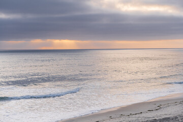 Ocean views and sunset. Sun rays make their way through clouds and illuminate the ocean