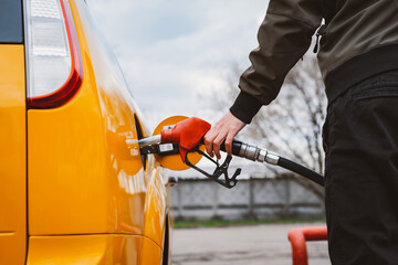 Unrecognizable man refueling car from gas station filling benzine gasoline fuel in car at gas...