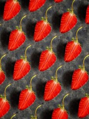 Beautiful background of fresh slices of strawberry with green tail on black concrete background. Set of strawberry. Summer berry. Fruit backdrop.