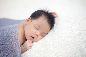 Obraz na płótnie Canvas Lovely newborn Asian baby sleeping on furry cloth