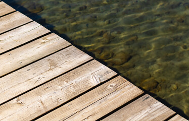 Wooden pier over water. Deck on a lake