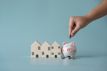 Piggy bank and small wooden house at back concept of savings. Save money to buy , loan , rent the house. - obrazy, fototapety, plakaty