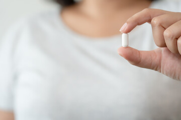 Woman carrying a supplement pill aspirin medicine health care concept. Get sick need a pill to...