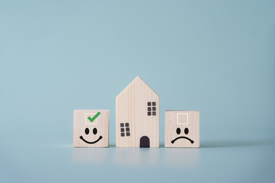 Tick box with facial expression and wooden house concept of things must do before buying house.