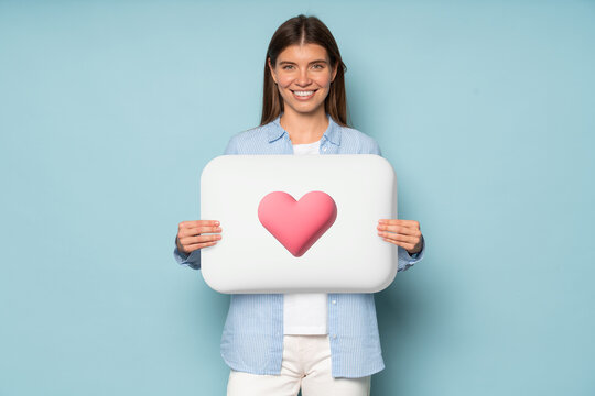 Smiling girl holding white button with like icon, isolated on blue background