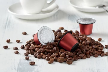 Acrylic prints Cafe Closeup of roasted coffee beans and coffee capsules