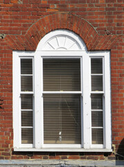 Beautiful white wooden window in a brick facade in the old city of Salisbury. England. United Kingdom.  