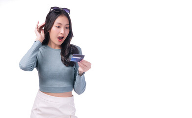 Fototapeta na wymiar Excited asian woman with sunglasses looking credit card in hand standing on white background. Cheerful surprised young girl holding blank card for payment online over isolated. Finance shopping online