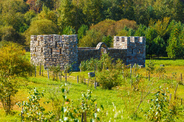 Stone medieval fortress in a green field.