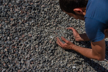 Crushed stones in the hands of a man. Selective focus.