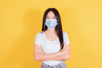 Portrait of Asian women in medical face mask to protect Covid-19 (Coronavirus) on yellow background, health and medicine concept