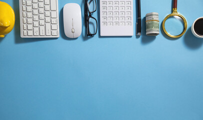 Piggy bank, money, coffee, calculator, eyeglasses on the blue background.