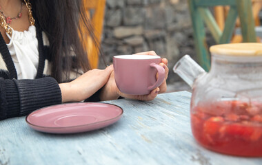 Woman drinking tasty tea at table in cafe.