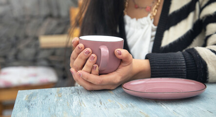 Woman drinking tasty tea at table in cafe.