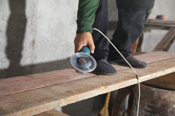 Worker holding electrical angle grinder. Industrial equipment