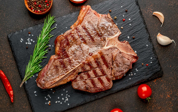 grilled T-bone steak or porterhouse Steak with herbs and salt on stone background
