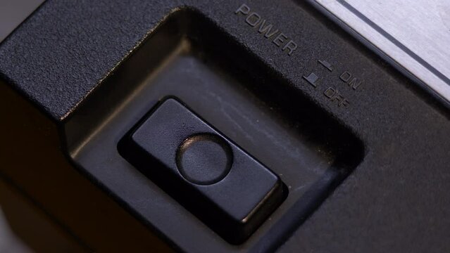 Angled shot of turning on and off the power button on a vintage audio player