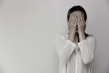 girl standing with hands covering her face feel pain with life's problems Suffering from Husband's Violence