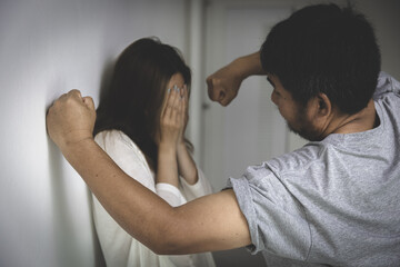 Fototapeta A man is about to attack a woman with a fist.Woman conceals her face in fear of domestic violence. obraz