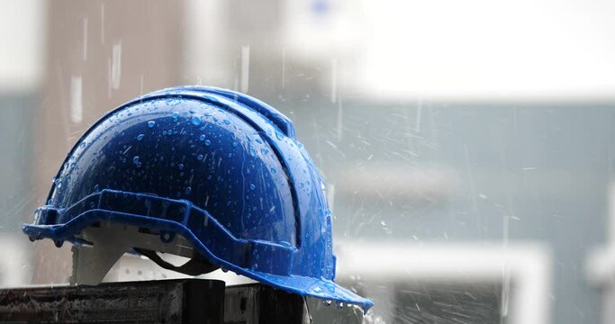Raindrops on a construction helmet,heavy rain and construction safety helmets, blue hard safety helmet and raining	