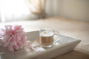 Coffee and pink peony on the tray/ breakfast in bed