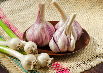 Garlic cloves in a bowl on burlap.
