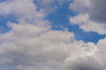 Naklejka na ściany i meble Beautiful white clouds on a bright blue background.