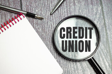 Credit Union. the inscription on magnifying glass on wooden background