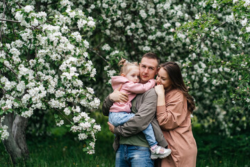  family mom mom baby daughter in the garden blooming apple trees
