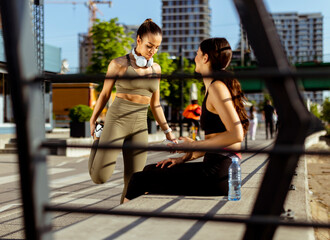 Young women in sportswear exercising on a river promenade