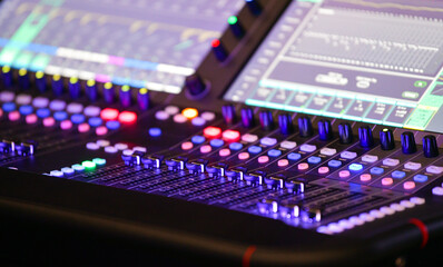 Music tehnician while sound recording studio mixing desk. Sound engineer or music producer working during an event on a digital mixing panel.