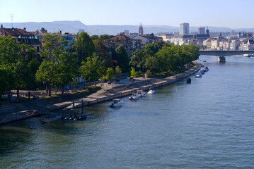 Obraz premium Aerial view over Rhine River with moored motor boats and people walking on boardwalk on a sunny spring day. Photo taken May 11th, 2022, Basel, Switzerland.