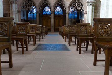 Inside famous church Basler Münster with beautiful stained glass and wooden chairs at the old town of Basel on a sunny spring day. Photo taken May 11th, 2022, Basel, Switzerland.