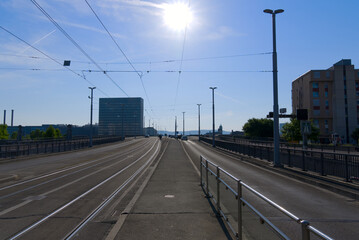 Fototapeta na wymiar Bridge named Dreirosenbrücke with tramway and pedestrians at City of Basel on a sunny spring day. Photo taken May 11th, 2022, Basel, Switzerland.
