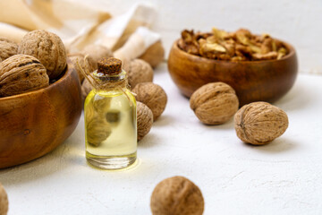 Glass bottle with essence, raw walnut peeled and in their shells, rustic style, selective focus