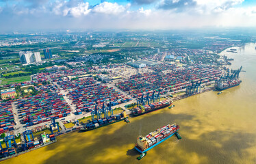 Aerial view of Cat Lai port with cargo ship and container Ho chi Minh city, Vietnam. The port is an important hub for import and export of important goods in Ho Chi Minh City - obrazy, fototapety, plakaty