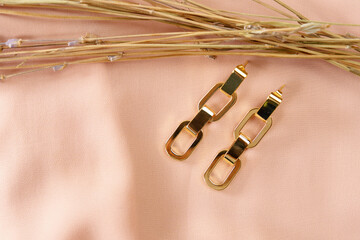 Naklejka premium Gold earrings close-up decoration. Luxury female jewelry.