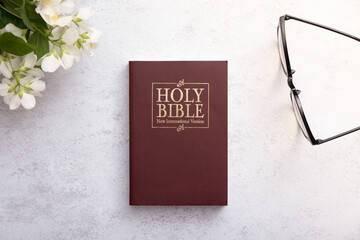 Top view of the Holy Bible on the desktop with glasses. The concept of Bible study