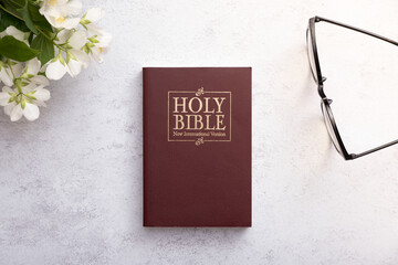Top view of the Holy Bible on the desktop with glasses. The concept of Bible study