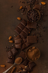Chocolate background with chocolate pieces, chocolate chips, nuts, cocoa