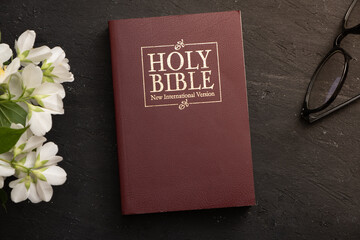 Top view of the Holy Bible on the desktop with glasses. The concept of Bible study