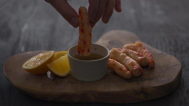 Slow motion man tasting crab meat with lemon and sauce