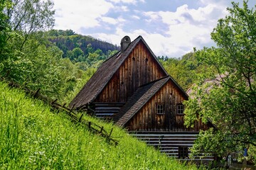 A timbered house with a interesting double roof located in the village of Zubrnice, open-air museum, Czechia, in the romantic hilly countryside