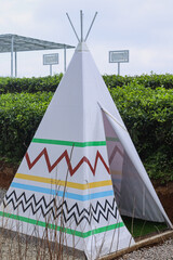 Close-up of wigwam house with view of tea plantation.  © Gatot