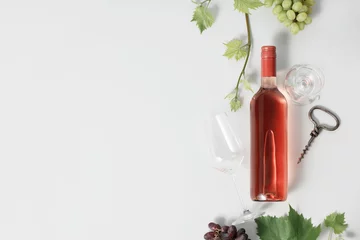 Rolgordijnen Bottle of Rose wine and grape. Flat-lay of rose wine on white background © Natalia Klenova
